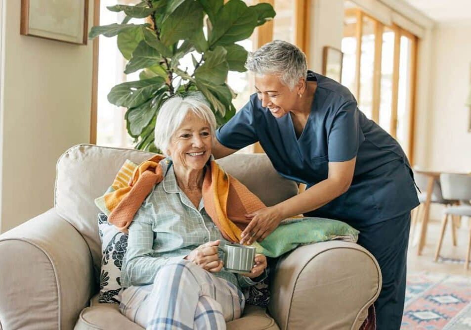 Aide giving an older woman a blanket