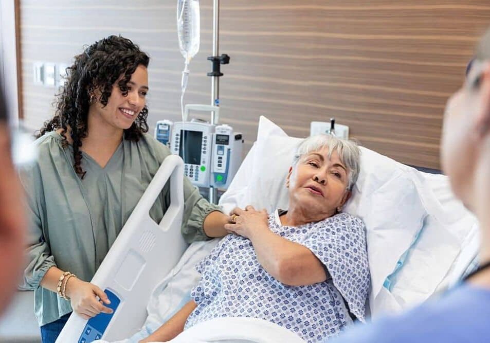 older woman in the hospital with daughter and nurse