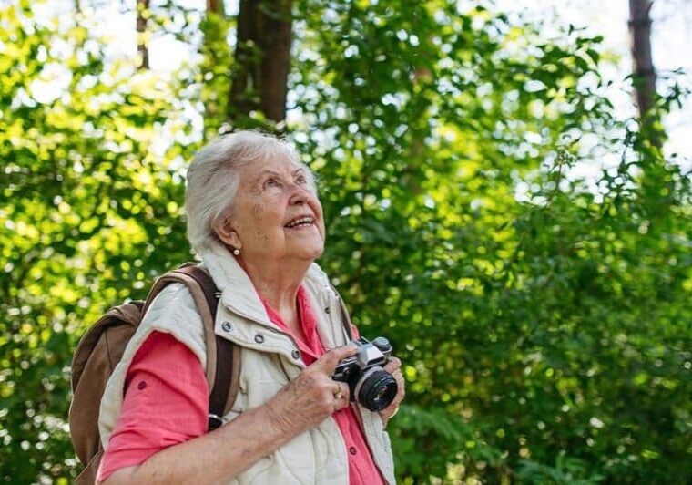 Older woman taking photographs in nature